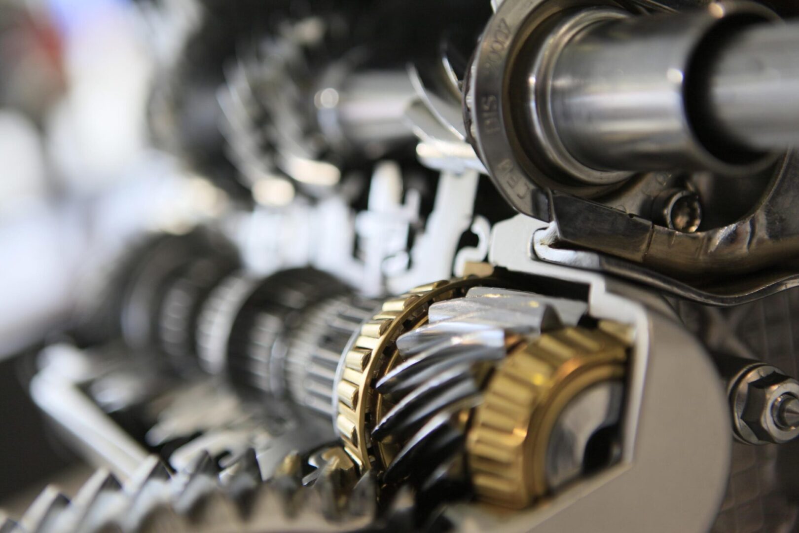 Close-up of a mechanical gearbox with interlocking gears and metal shafts, highlighting intricate engineering and precise alignment of components.